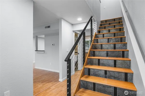 a view of entryway with wooden floor and cabinets