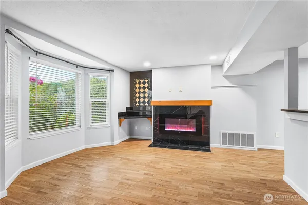a view of an empty room with a fireplace and a window