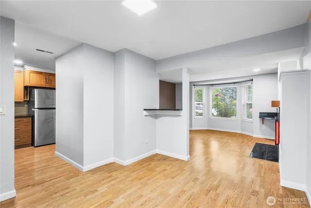 a view of a big room with wooden floor and windows