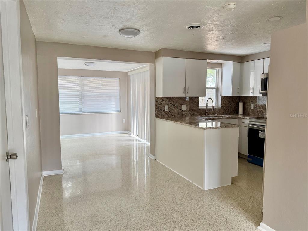 7441 Banner Street New Port Richey, FL 34653 - Photo 10 of 20 a kitchen with stainless steel appliances a sink stove and cabinets