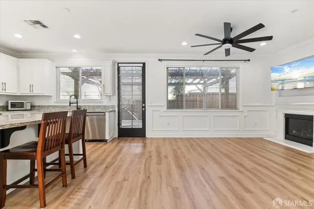 a view of empty room with wooden floor and fan