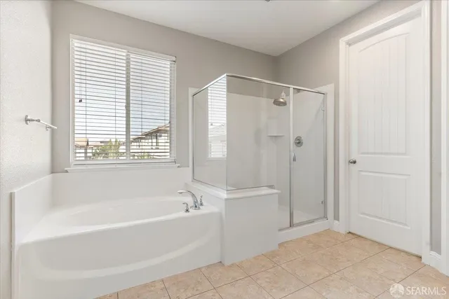 a bathroom with a tub sink shower and mirror