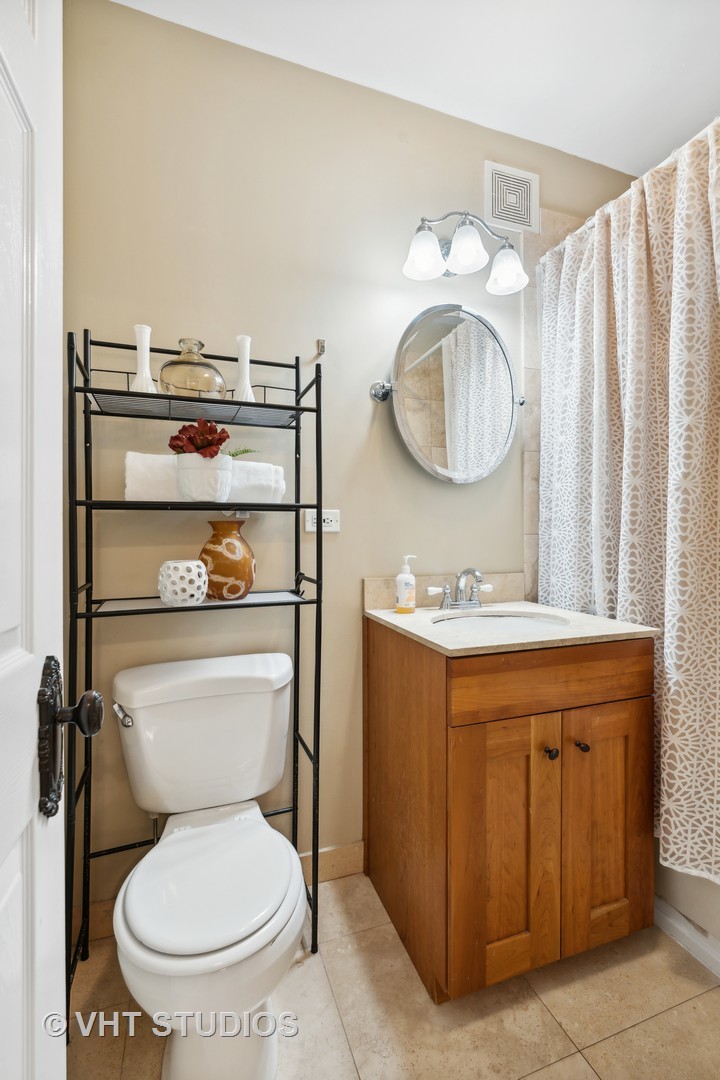 1155 West Grace Street, Unit 2N Chicago, IL 60613 - Photo 16 of 20 a bathroom with a toilet sink and mirror