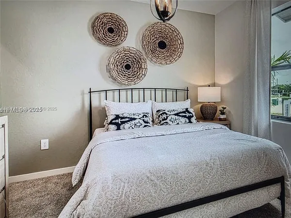 a bed with a white comforter and pillows
