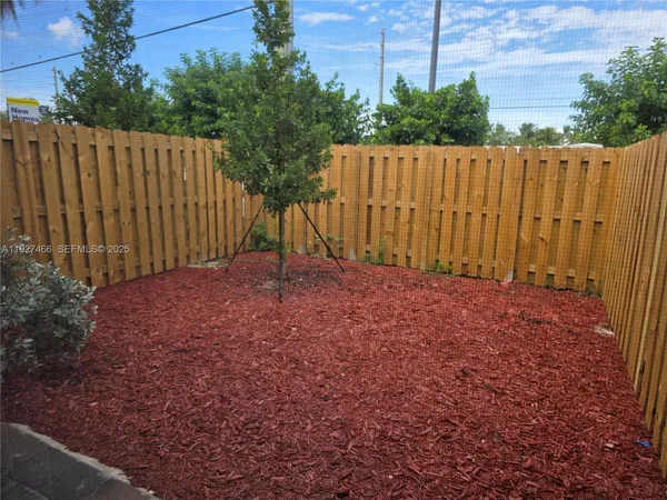 a view of backyard with wooden fence