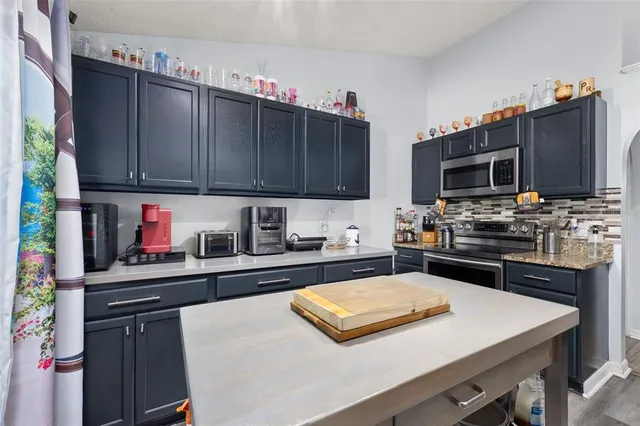 a kitchen with stainless steel appliances a stove refrigerator sink and microwave
