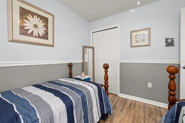 a bedroom with bed and wooden floor