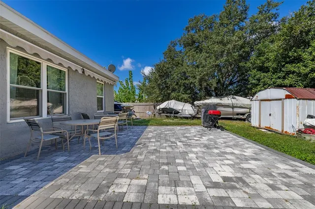 a view of a patio with table and chairs with wooden floor and fence