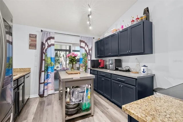 a kitchen with kitchen island granite countertop a sink stove and cabinets