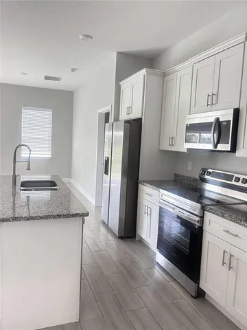 a kitchen with stainless steel appliances granite countertop a refrigerator stove and sink