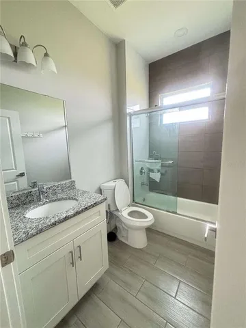 a bathroom with a granite countertop sink toilet and shower