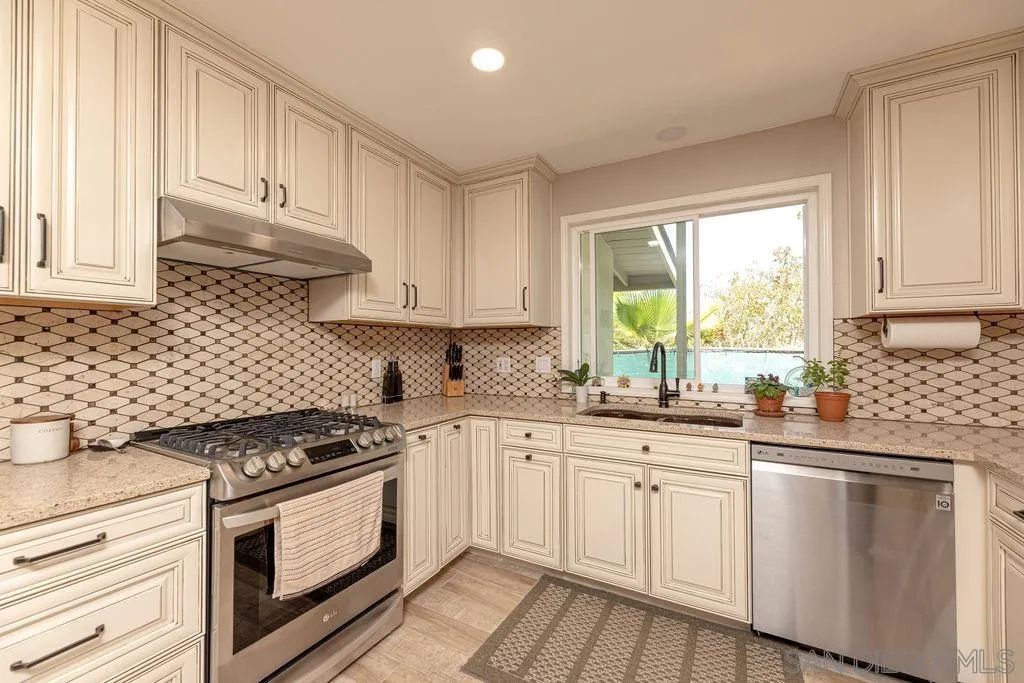 12317 Witt Road Poway, CA 92064 - Photo 15 of 43 a kitchen with granite countertop white cabinets and white appliances