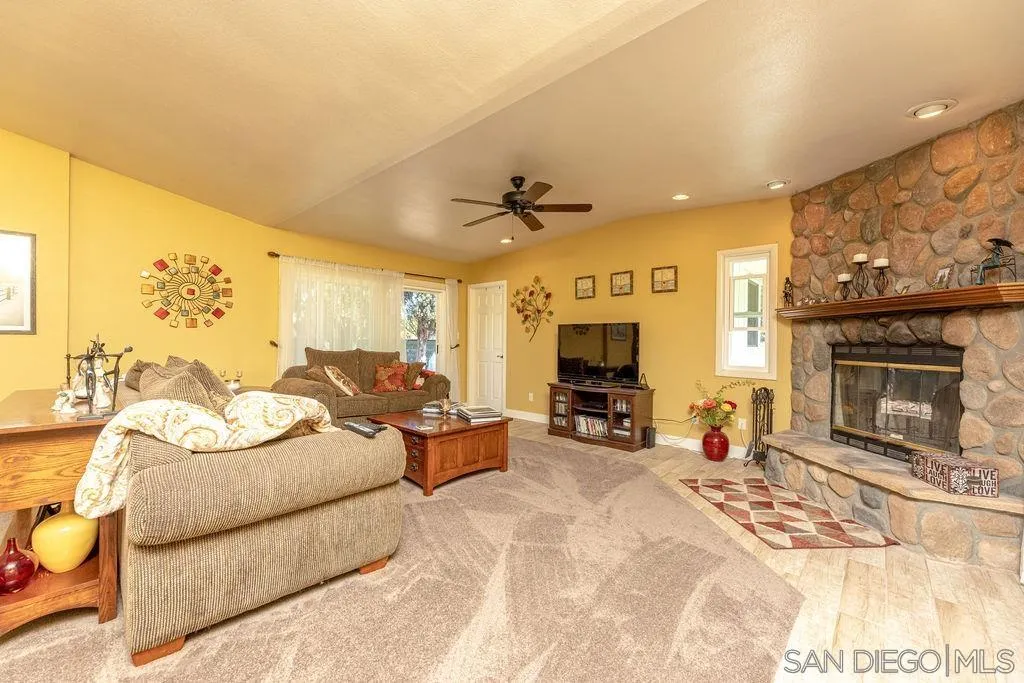 12317 Witt Road Poway, CA 92064 - Photo 18 of 43 a living room with furniture a fireplace and a flat screen tv