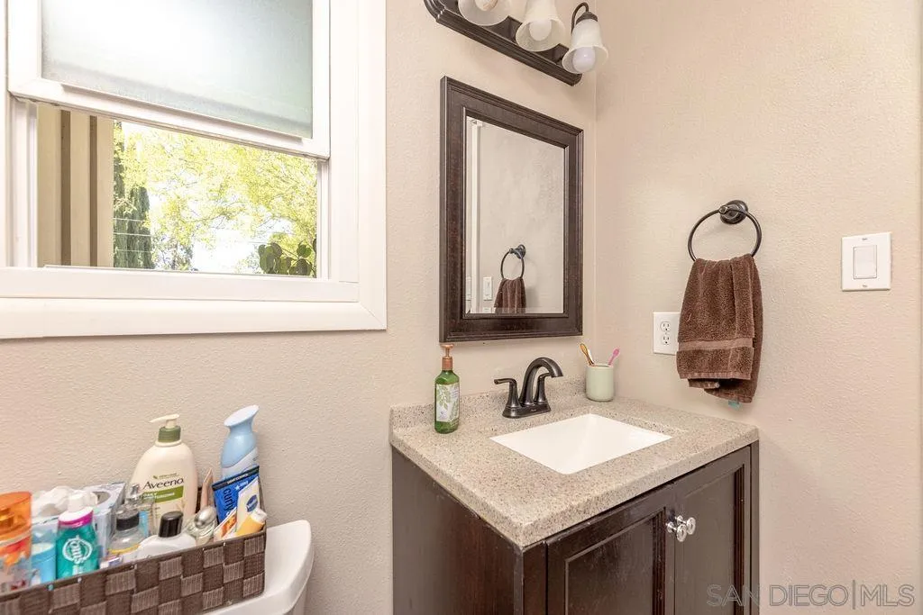 12317 Witt Road Poway, CA 92064 - Photo 27 of 43 a bathroom with a granite countertop sink and a mirror
