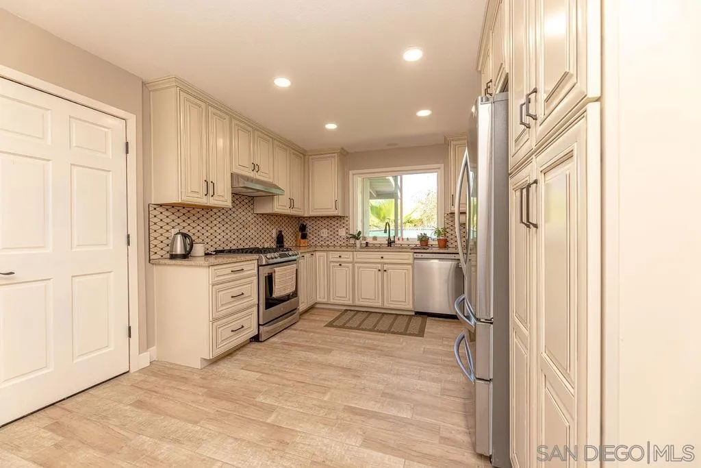 12317 Witt Road Poway, CA 92064 - Photo 38 of 43 a kitchen with white cabinets and white appliances
