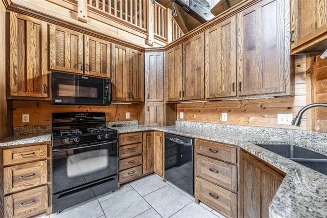 a kitchen with stainless steel appliances granite countertop a stove microwave and cabinets