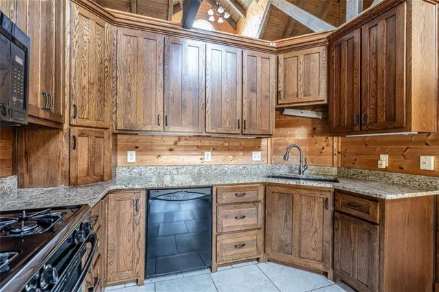 a kitchen with granite countertop a sink stainless steel appliances and cabinets