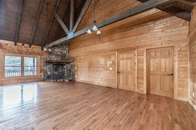 a view of empty room with wooden floor and fireplace