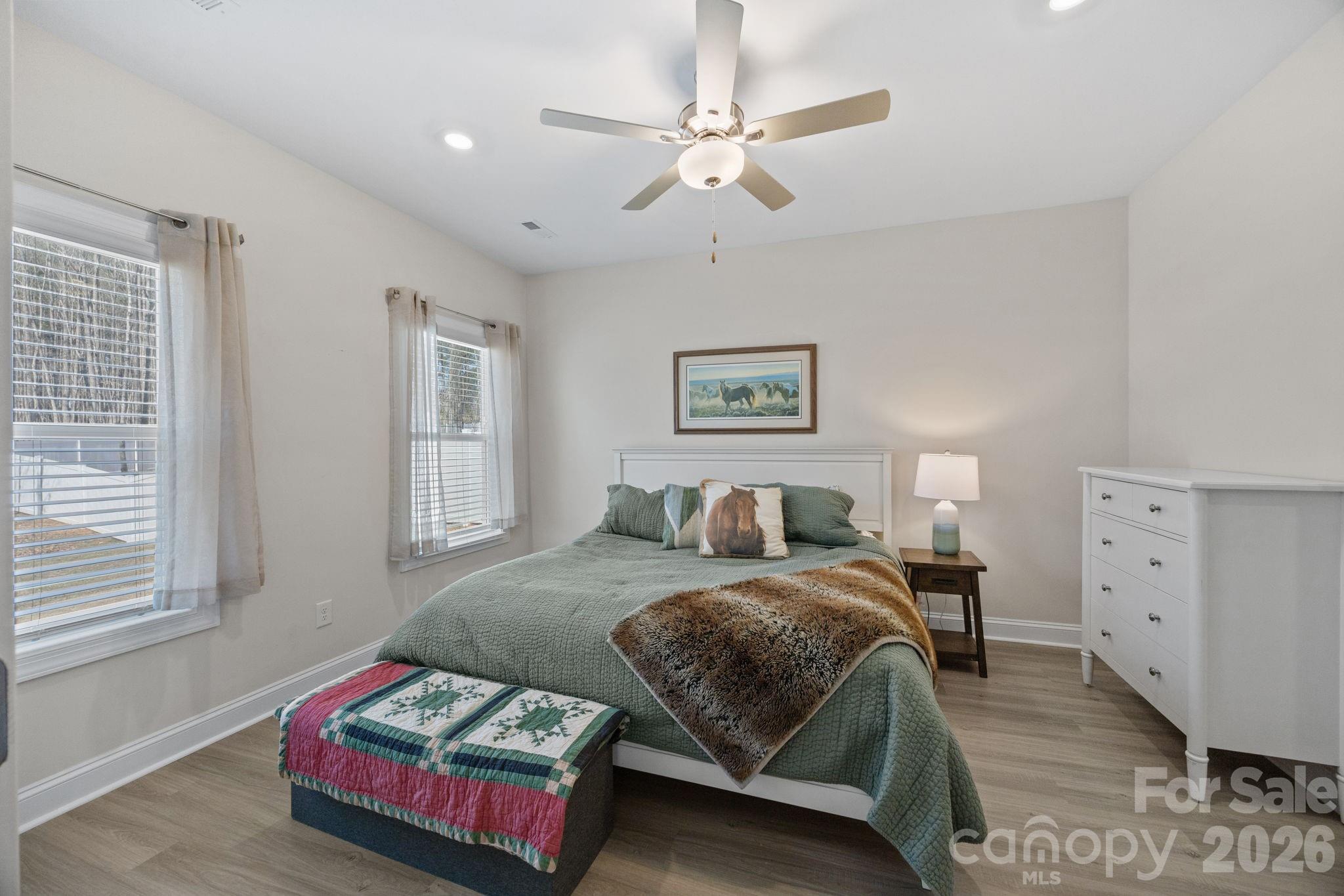 181 Brixham Loop Troutman, NC 28166 - Photo 11 of 28 a bedroom with a bed and a chandelier