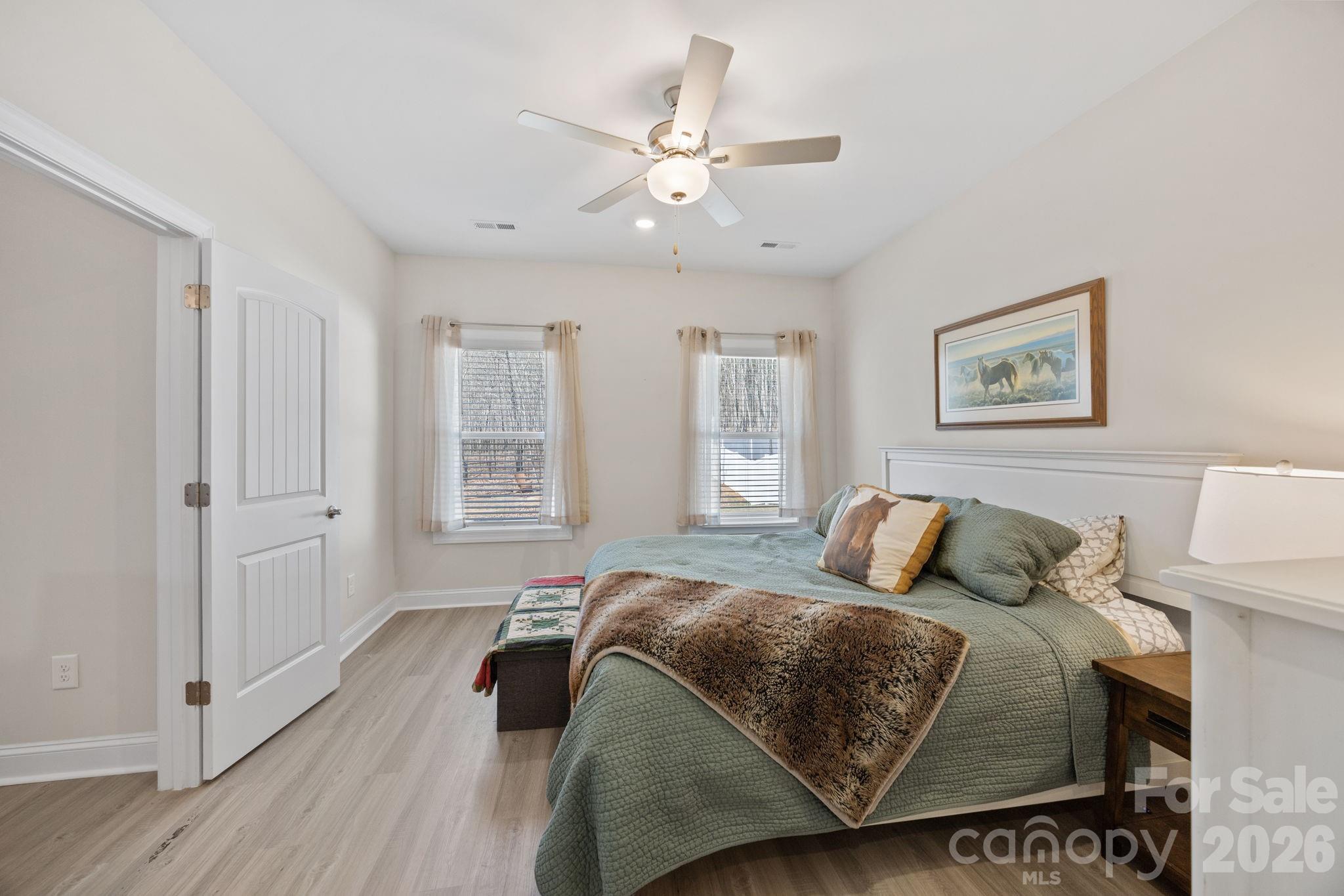 181 Brixham Loop Troutman, NC 28166 - Photo 12 of 28 a bedroom with a large bed and a chandelier