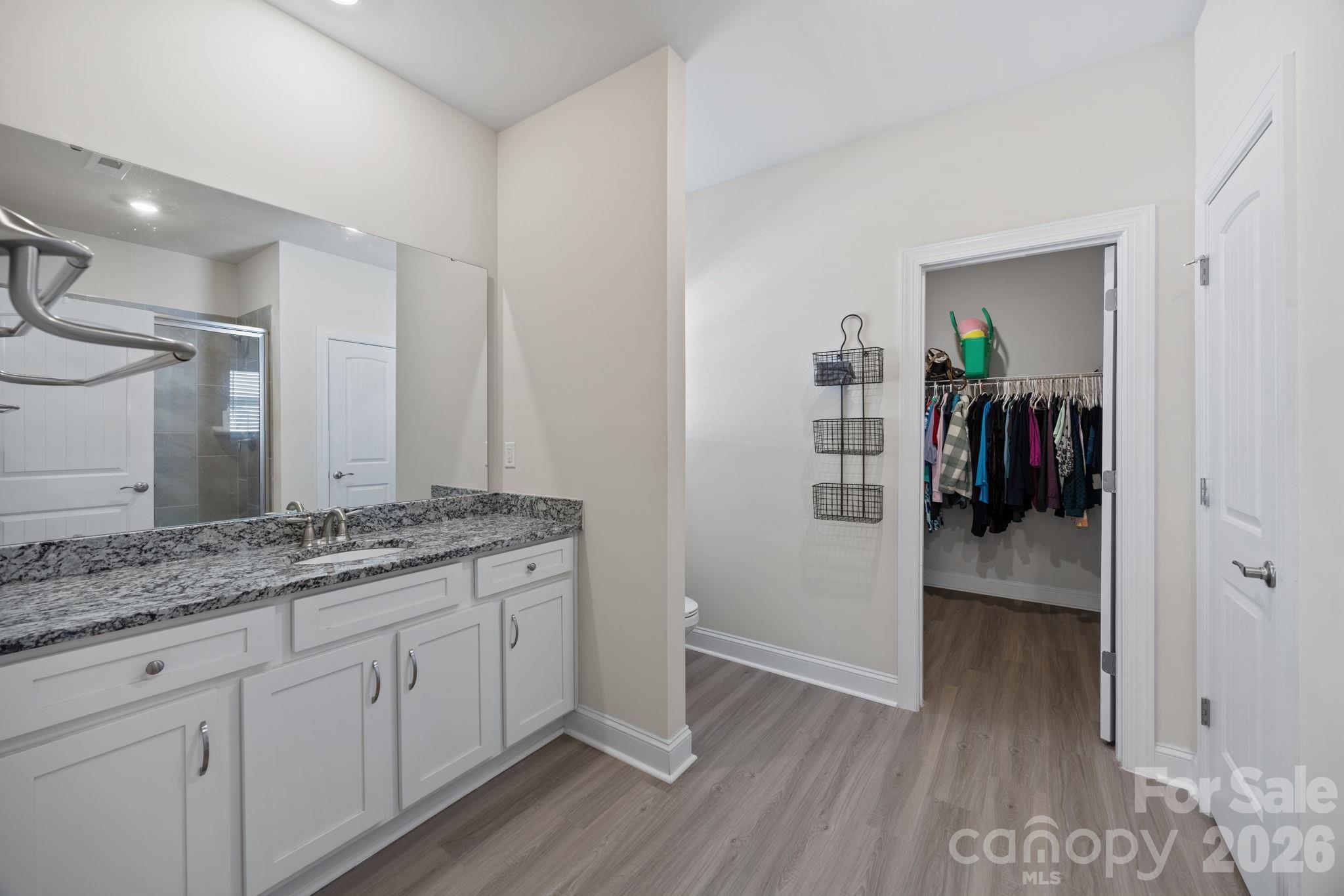 181 Brixham Loop Troutman, NC 28166 - Photo 13 of 28 a bathroom with a granite countertop sink and a mirror