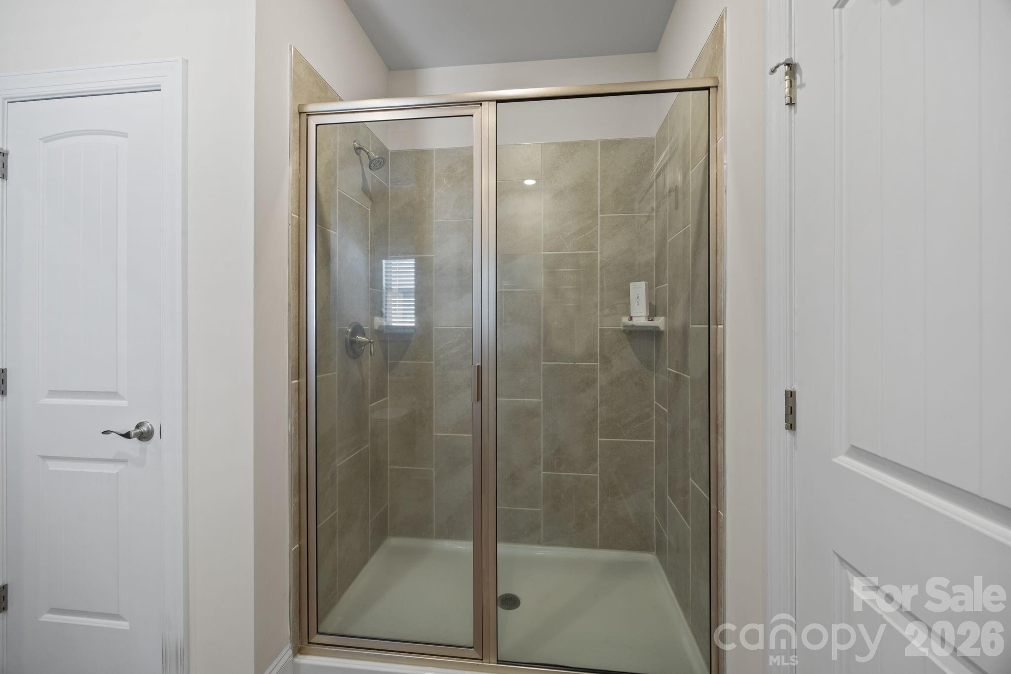 181 Brixham Loop Troutman, NC 28166 - Photo 14 of 28 a bathroom with a glass shower door