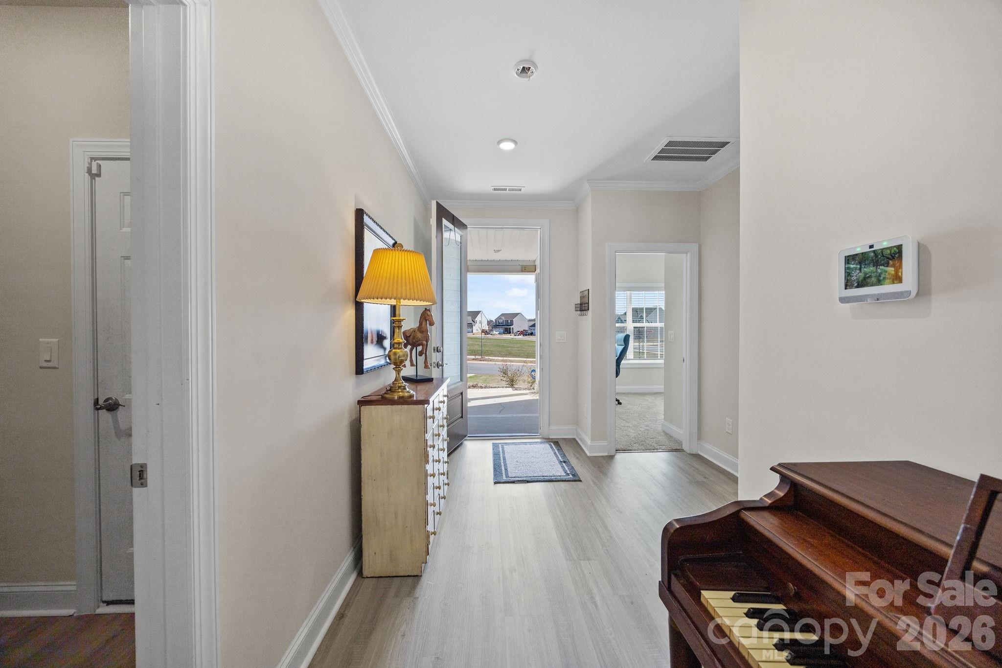 181 Brixham Loop Troutman, NC 28166 - Photo 16 of 28 a view of a hallway with wooden floor and furniture