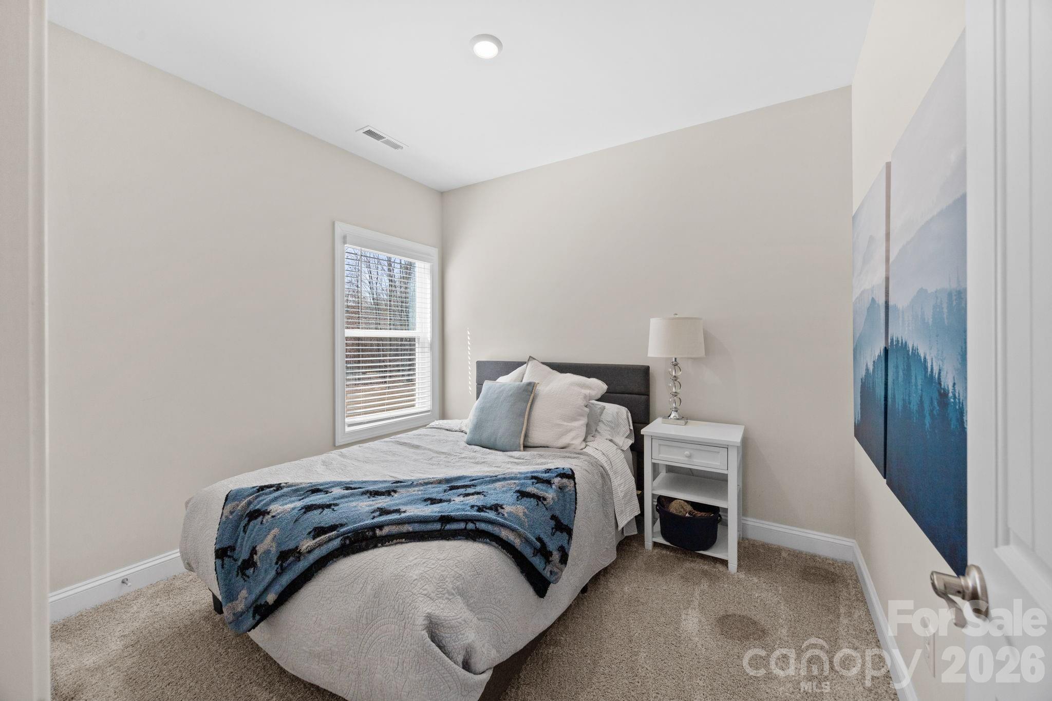 181 Brixham Loop Troutman, NC 28166 - Photo 18 of 28 a bedroom with a bed and a window