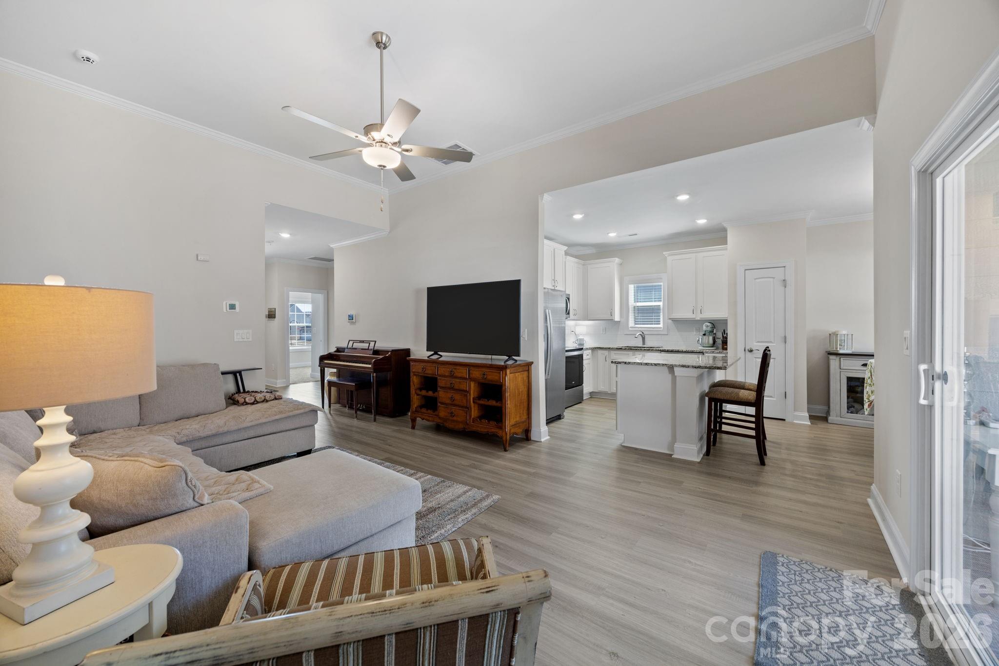 181 Brixham Loop Troutman, NC 28166 - Photo 5 of 28 a living room with furniture kitchen view and a flat screen tv