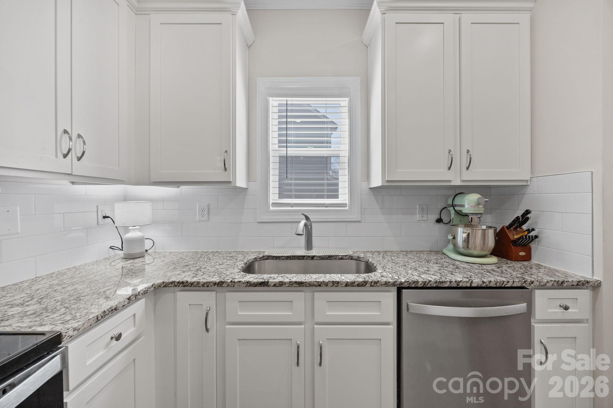 181 Brixham Loop Troutman, NC 28166 - Photo 8 of 28 a kitchen with granite countertop white cabinets and a sink