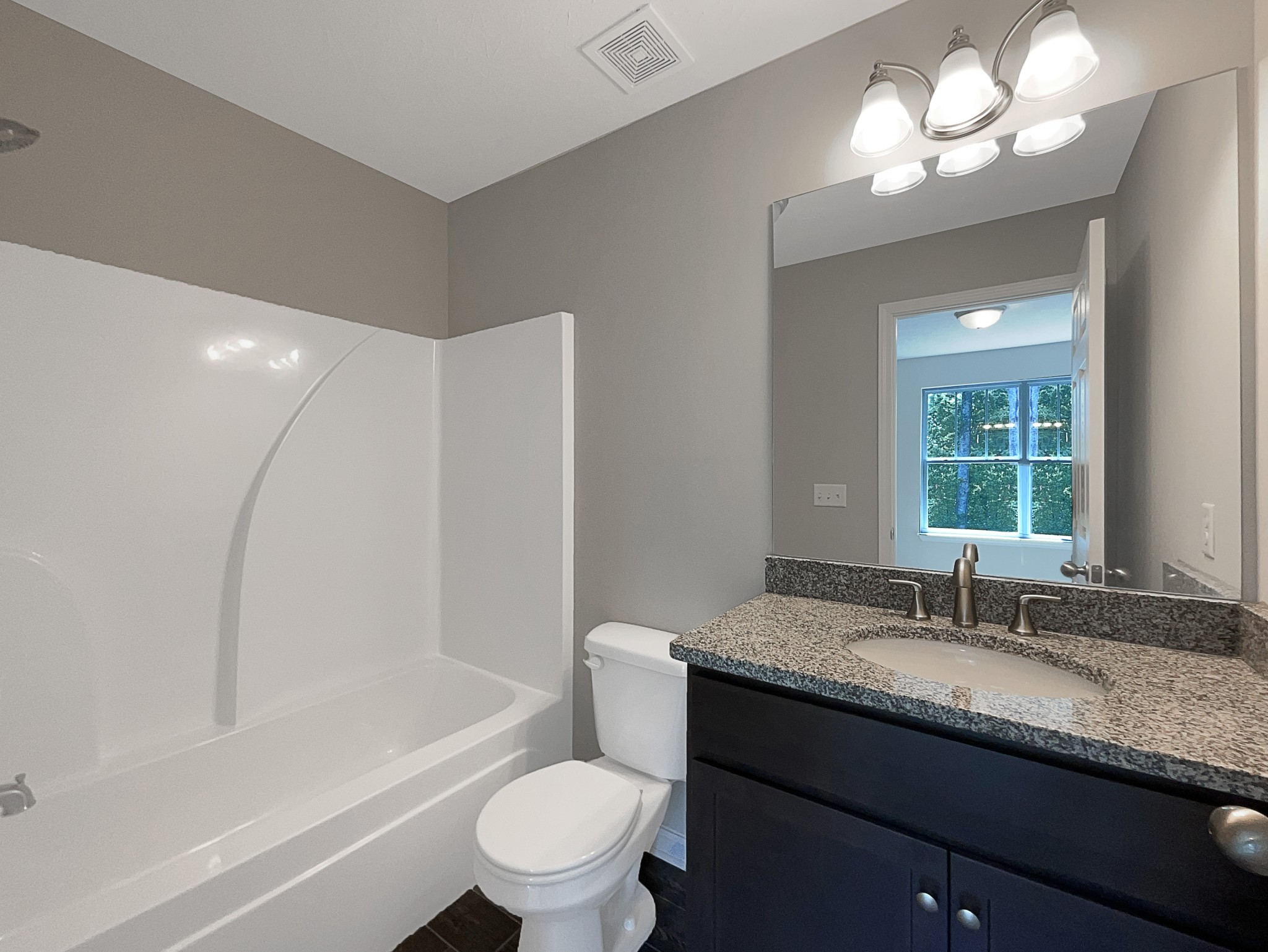 1382 Rural Hill Road, Unit 364 Antioch, TN 37013 - Photo 17 of 22 a bathroom with a granite countertop sink toilet a large mirror a bathtub and shower