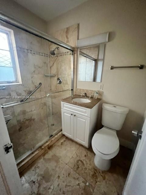 West Flagler Miami, FL 33126 - Photo 13 of 21 a bathroom with a granite countertop toilet a sink a mirror and a shower