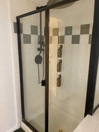 a bathroom with a shower and mirror
