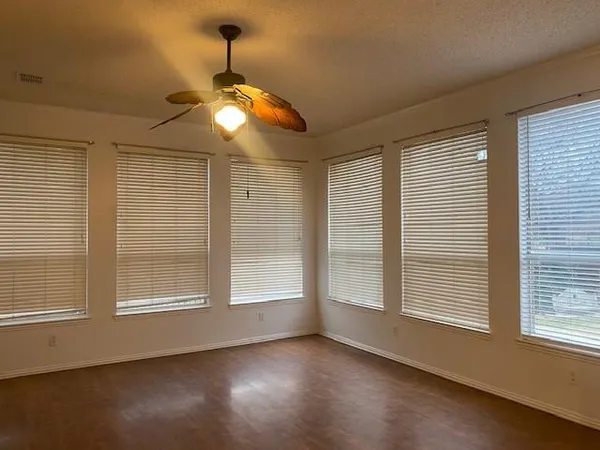 a view of wooden floor and a chandelier fan in a room