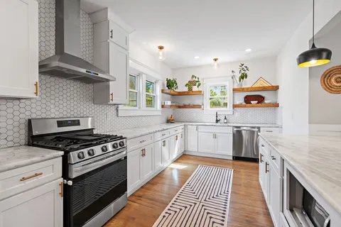 a kitchen with stainless steel appliances granite countertop a stove and cabinets
