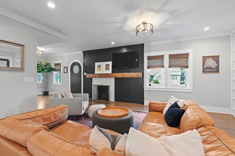 a living room with furniture a fireplace and a flat screen tv