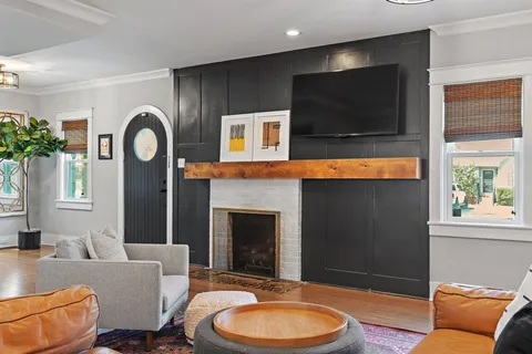 a living room with furniture a flat screen tv and a fireplace
