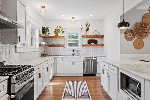 a kitchen with stainless steel appliances granite countertop a stove and a sink