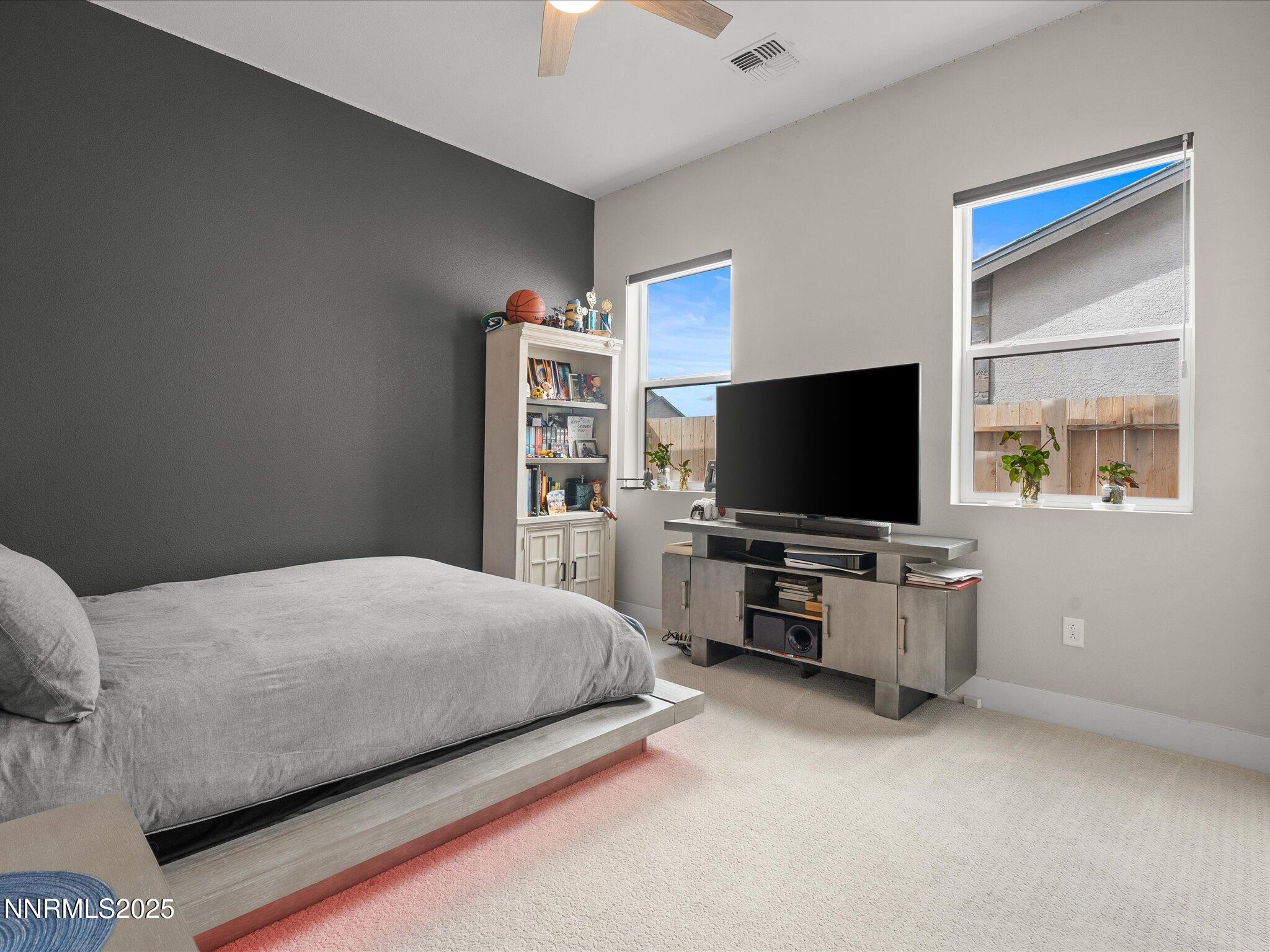 15026 Iron River Drive Reno, NV 89521 - Photo 13 of 26 a bedroom with a bed and a flat screen tv