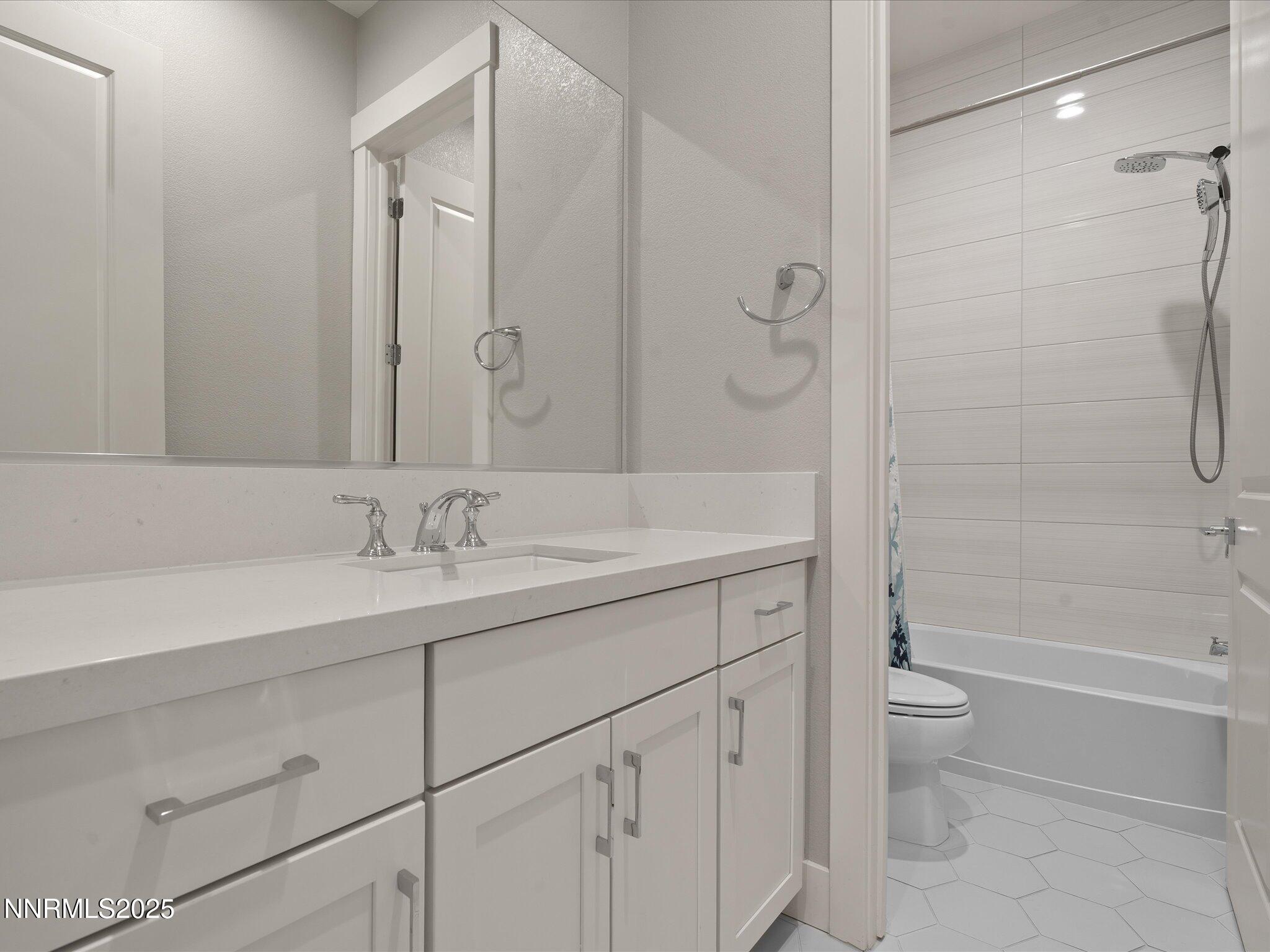 15026 Iron River Drive Reno, NV 89521 - Photo 14 of 26 a bathroom with a granite countertop sink a toilet and shower