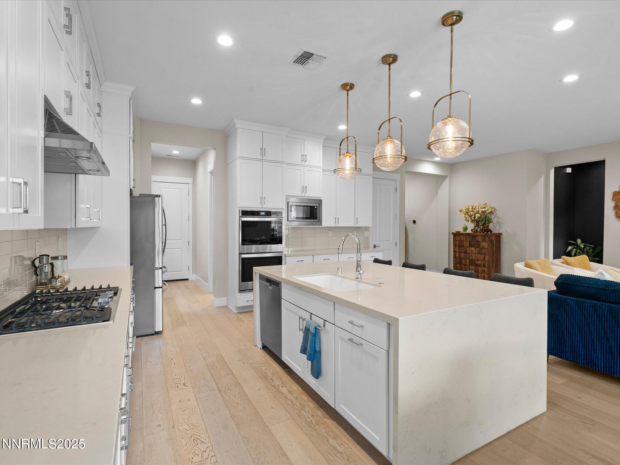 15026 Iron River Drive Reno, NV 89521 - Photo 5 of 26 a large kitchen with stainless steel appliances kitchen island a large island in the center