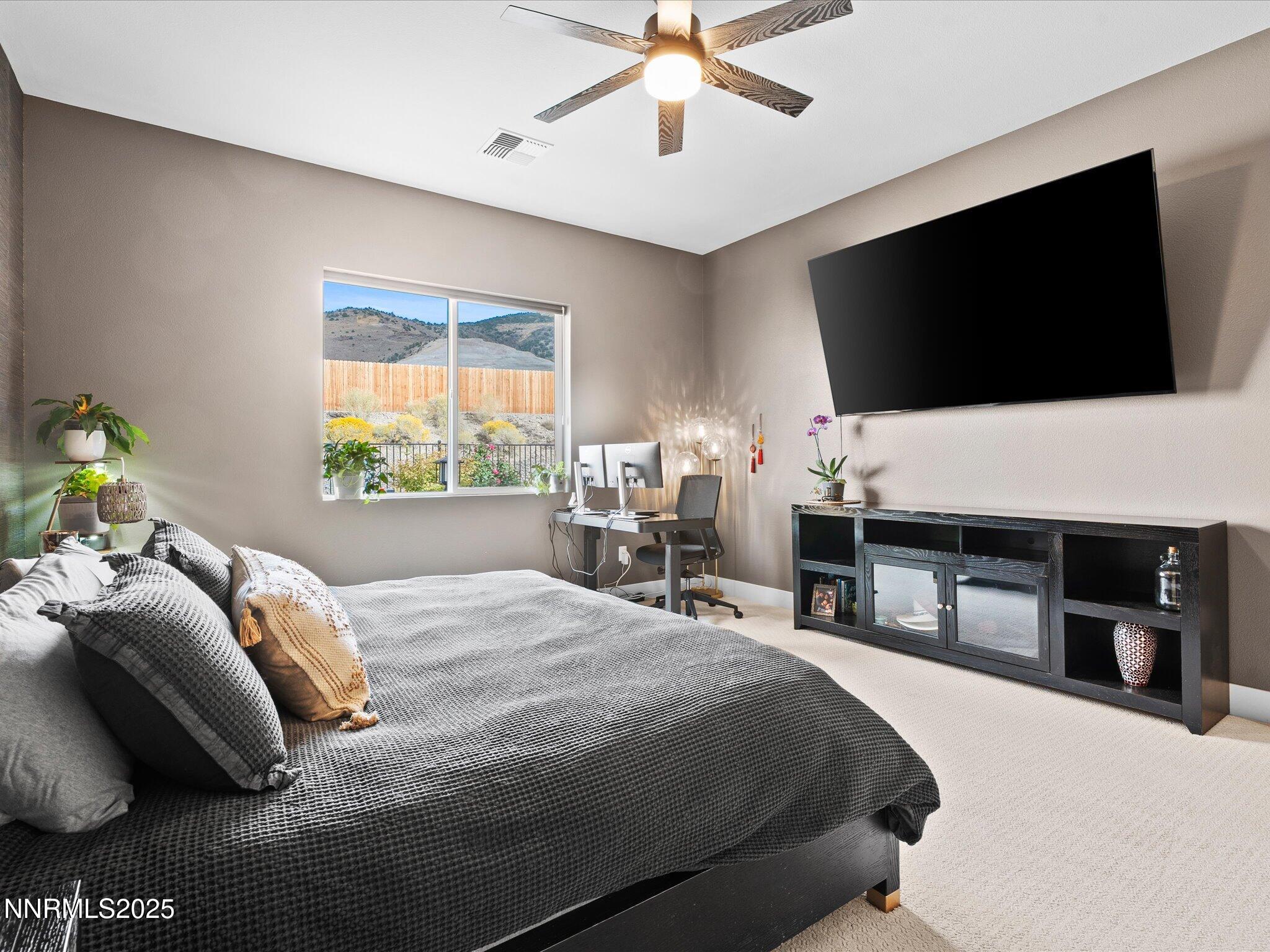 15026 Iron River Drive Reno, NV 89521 - Photo 10 of 26 a bedroom with a bed and a flat screen tv