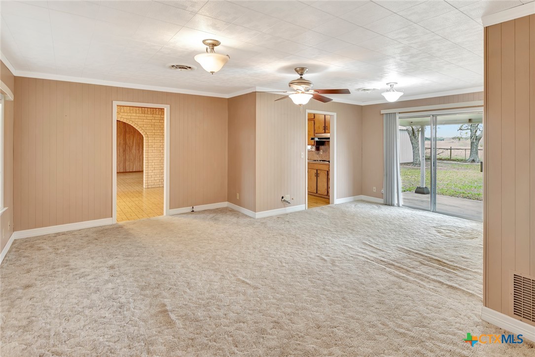 1840 Loop 522 Ganado, TX 77962 - Photo 21 of 48 an empty room with chandelier fan and kitchen view