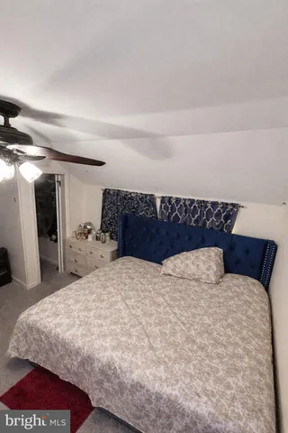 a large bed sitting in a bedroom and a mirror