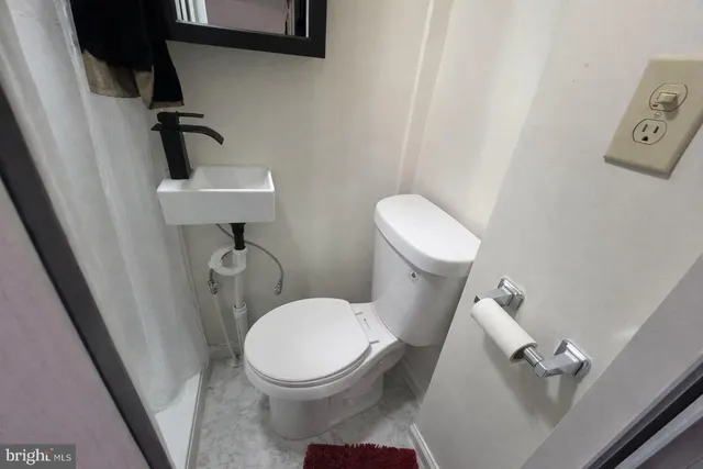 a white toilet sitting next to a small sink