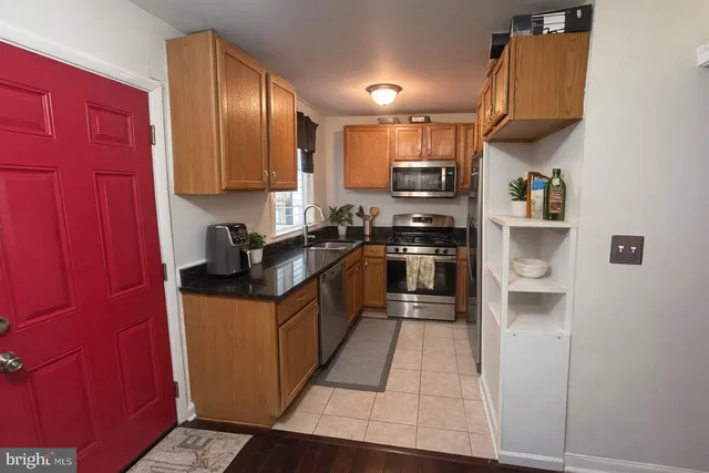 a kitchen with stainless steel appliances granite countertop a stove a sink and a refrigerator