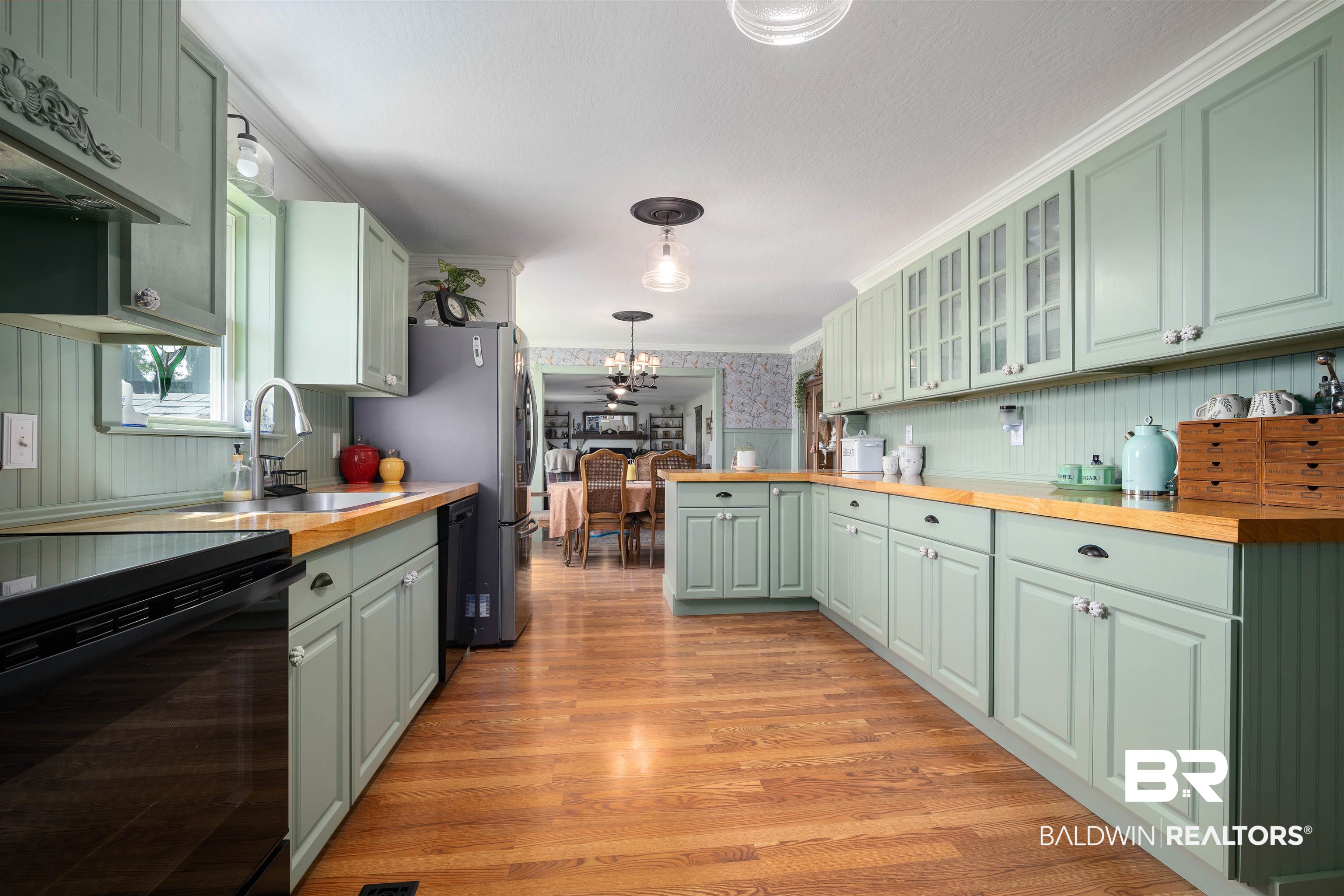 22 Horace Odom Road Millry, AL 36558 - Photo 9 of 39 Kitchen featuring wallpapered walls, butcher block counters, glass insert cabinets, exhaust hood, and light wood-style floors
