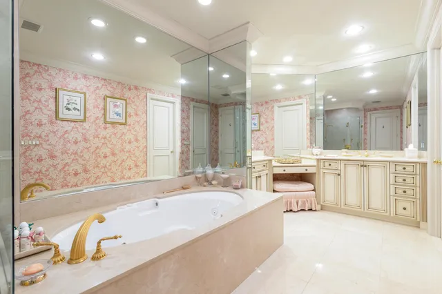 a bathroom with a large tub sink vanity granite and a shower