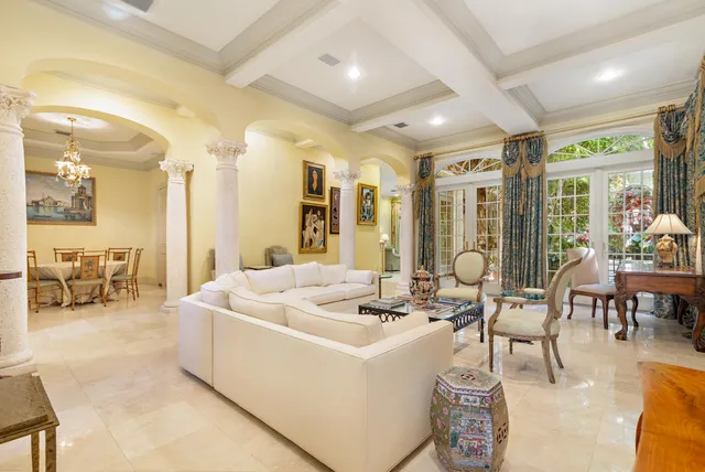 a living room with couches and kitchen view with wooden floor