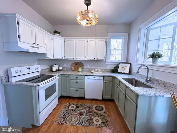 a kitchen with a stove sink and cabinets